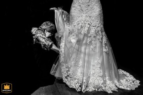 Bridal preparations at a Dutch wedding as the mother of the bride assists in her daughter's dress up - striking black and white photo.